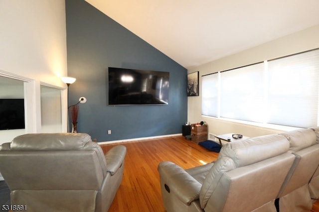 living room featuring high vaulted ceiling and hardwood / wood-style flooring