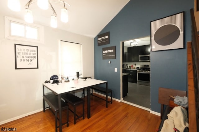 dining space featuring lofted ceiling and hardwood / wood-style floors