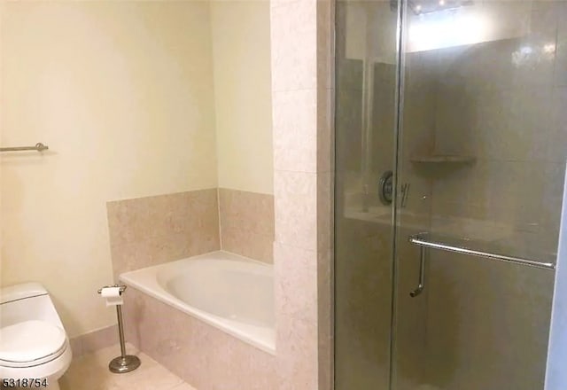 bathroom featuring tile patterned flooring, toilet, and separate shower and tub