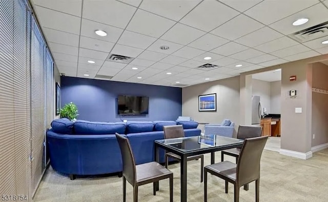 dining room with a drop ceiling and light colored carpet