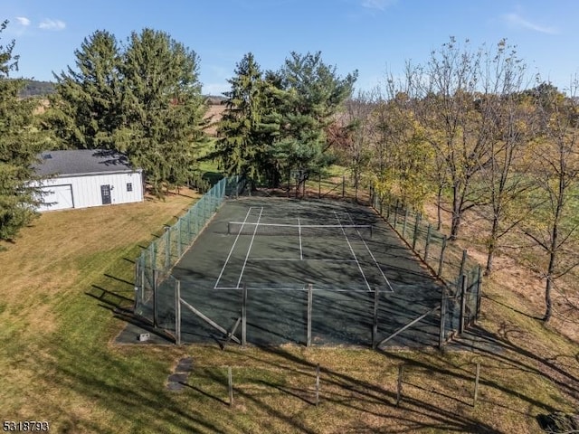 view of sport court with fence and a lawn