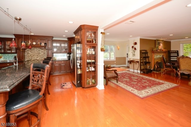 interior space with a fireplace, crown molding, light hardwood / wood-style flooring, and sink