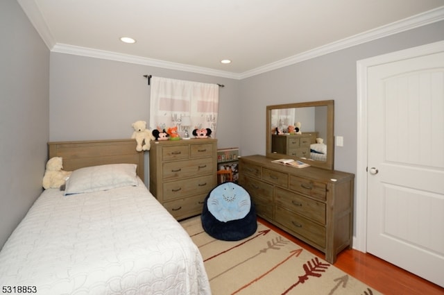 bedroom with ornamental molding and hardwood / wood-style floors