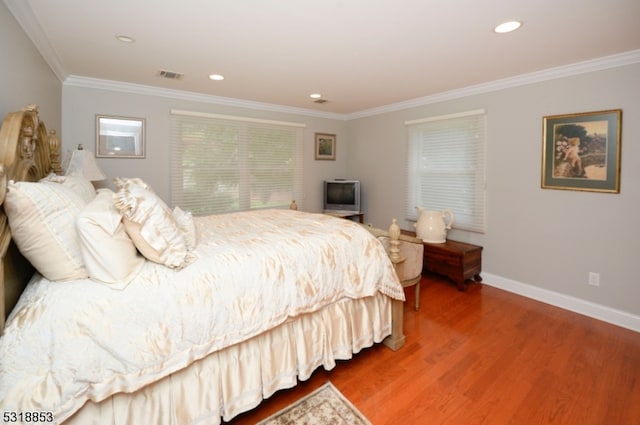 bedroom with hardwood / wood-style flooring and crown molding