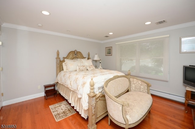 bedroom featuring ornamental molding, hardwood / wood-style floors, and a baseboard heating unit