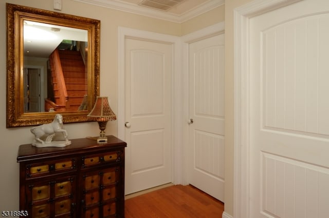 hallway with crown molding and light hardwood / wood-style floors