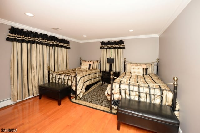 bedroom with wood-type flooring and ornamental molding