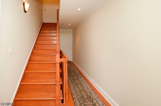 staircase with hardwood / wood-style floors and ornamental molding