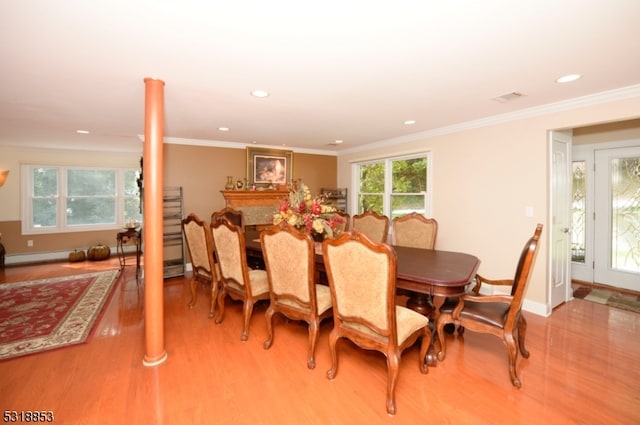 dining room featuring crown molding and light hardwood / wood-style floors