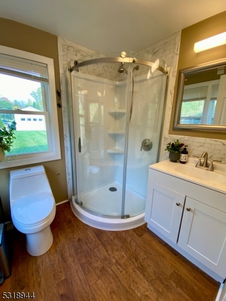 bathroom featuring vanity, toilet, backsplash, walk in shower, and hardwood / wood-style floors