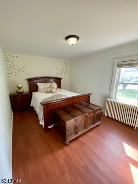 bedroom with radiator and hardwood / wood-style floors