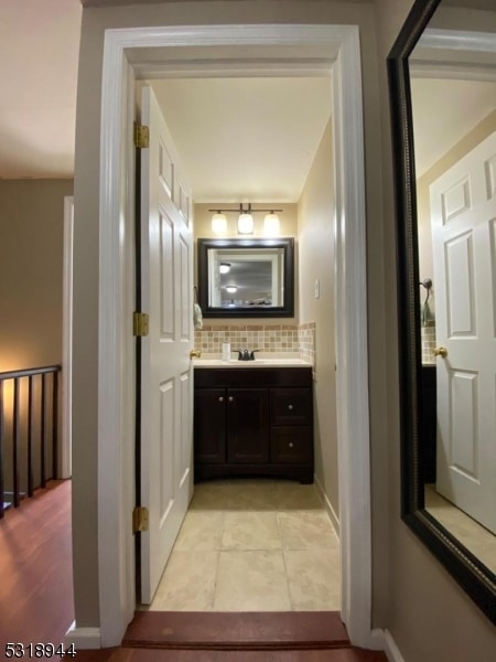 bathroom featuring tile patterned floors, decorative backsplash, and vanity