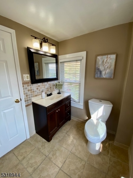 bathroom with backsplash, tile patterned floors, vanity, and toilet