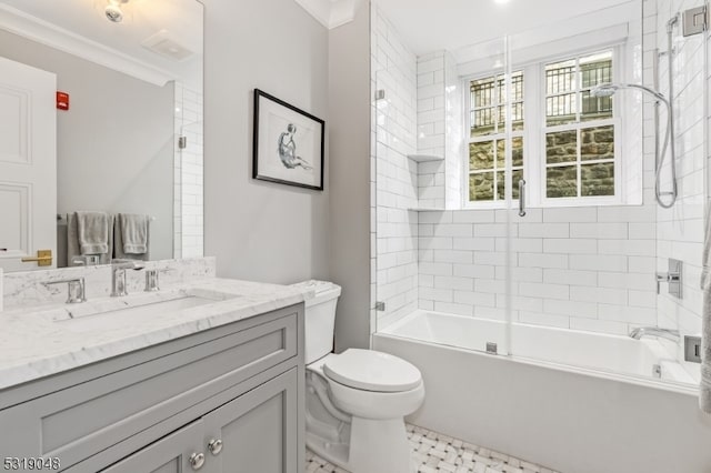 full bathroom featuring vanity, toilet, crown molding, and tiled shower / bath