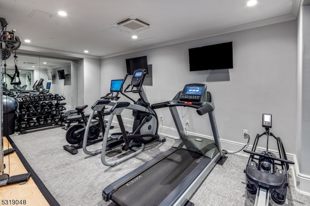 exercise room with ornamental molding and hardwood / wood-style floors