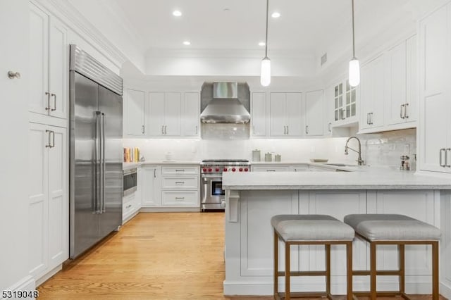 80 Claremont Rd Unit 802, Bernardsville Boro, NJ 07924 - kitchen featuring a peninsula, a sink, white cabinetry, wall chimney range hood, and high quality appliances