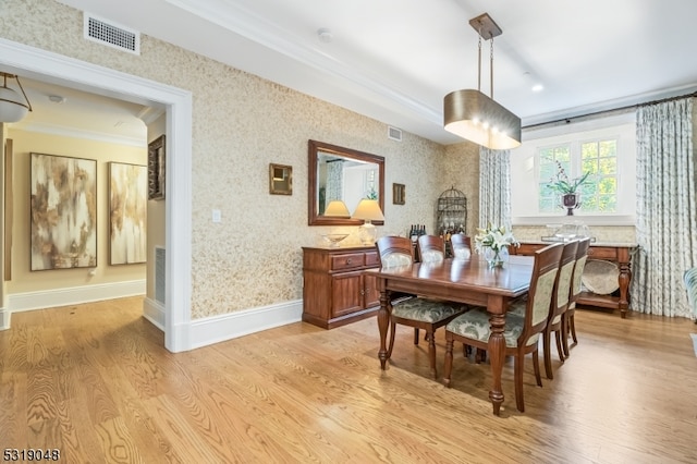 dining room featuring crown molding and light wood-type flooring