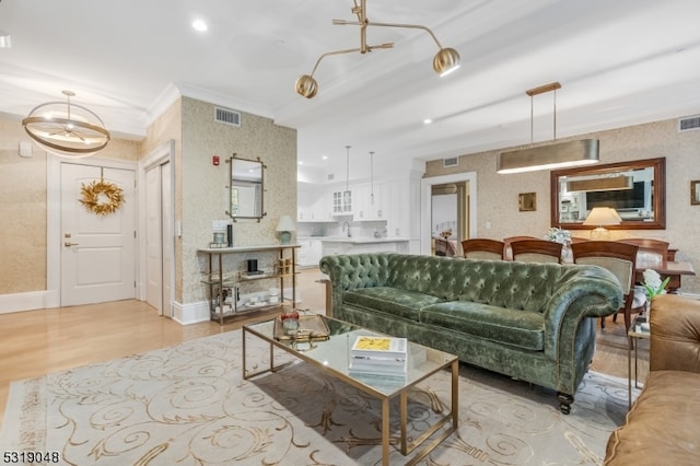 living room with light hardwood / wood-style floors and ornamental molding