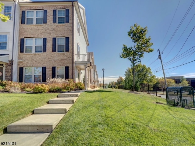 view of front of house with a front yard and a balcony