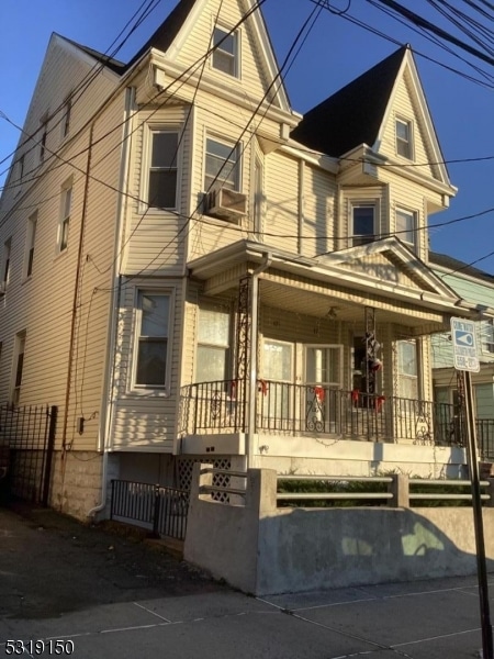 view of front of property featuring cooling unit and a porch