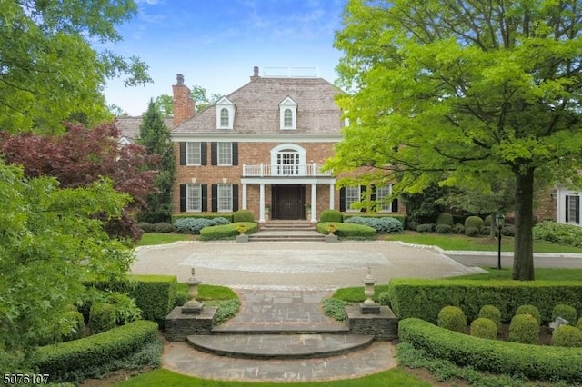 3 Winston Farm Ln, Mendham Twp, NJ 07931 - colonial-style house with brick siding, a chimney, and a balcony