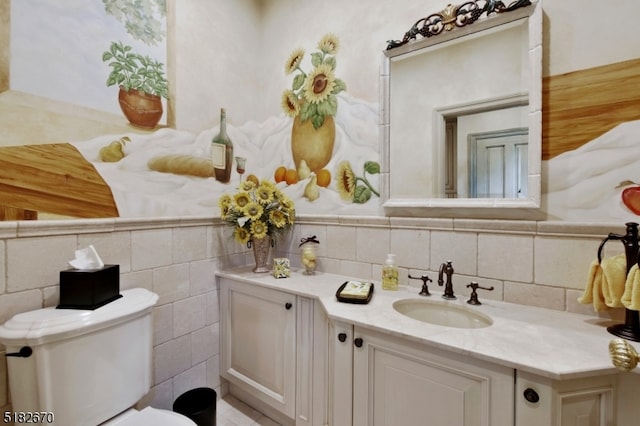 bathroom featuring vanity, toilet, and tile walls