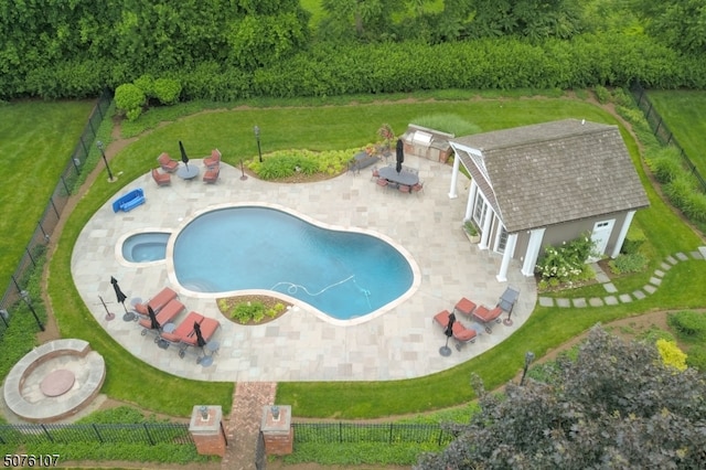 view of pool featuring an in ground hot tub, a patio area, a lawn, and an outbuilding