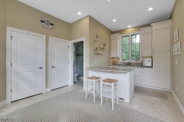 3 Winston Farm Ln, Mendham Twp, NJ 07931 - kitchen featuring baseboards, a kitchen breakfast bar, light tile patterned floors, a peninsula, and white cabinets