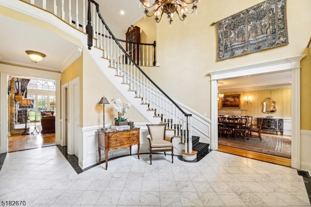 entrance foyer featuring ornamental molding and a towering ceiling