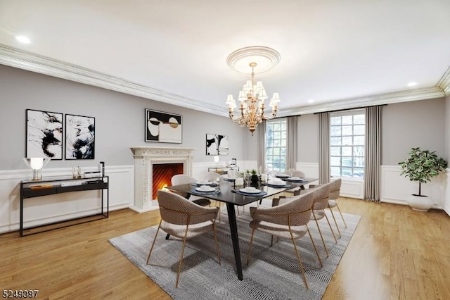 3 Winston Farm Ln, Mendham Twp, NJ 07931 - dining space with a chandelier, ornamental molding, light wood-style floors, a lit fireplace, and wainscoting