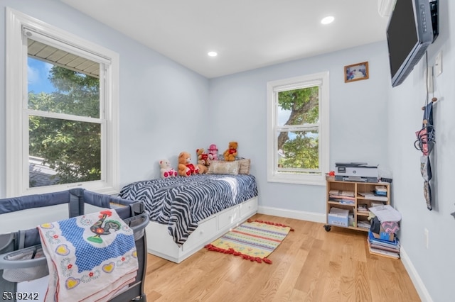 bedroom with light hardwood / wood-style flooring and multiple windows