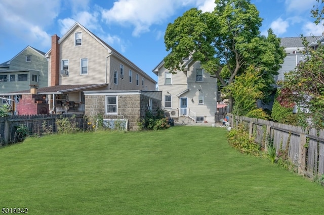 back of house with cooling unit and a lawn