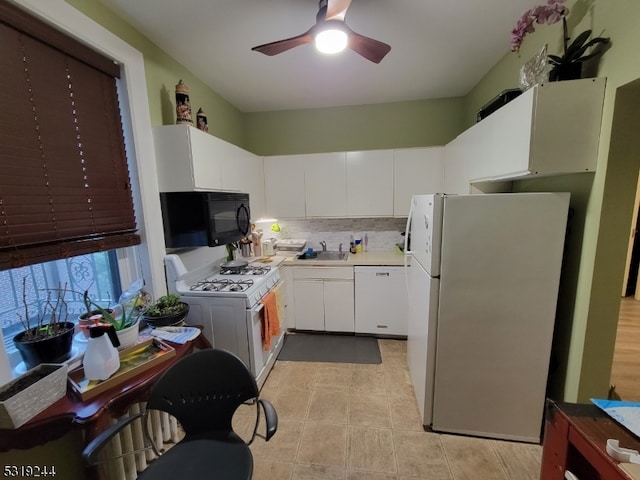 kitchen with white cabinetry, tasteful backsplash, white appliances, and sink