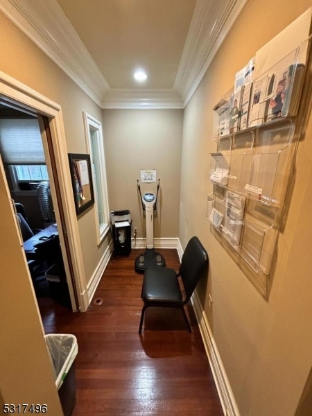 hall with dark wood-type flooring and crown molding