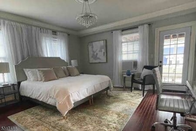 bedroom with an inviting chandelier and dark hardwood / wood-style flooring