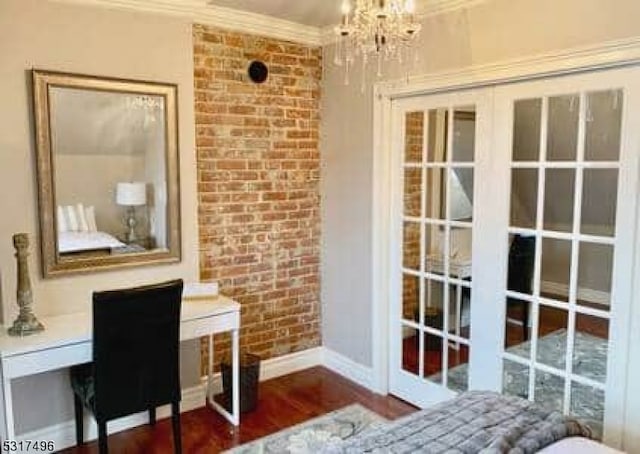 doorway featuring crown molding, brick wall, a chandelier, and dark wood-type flooring