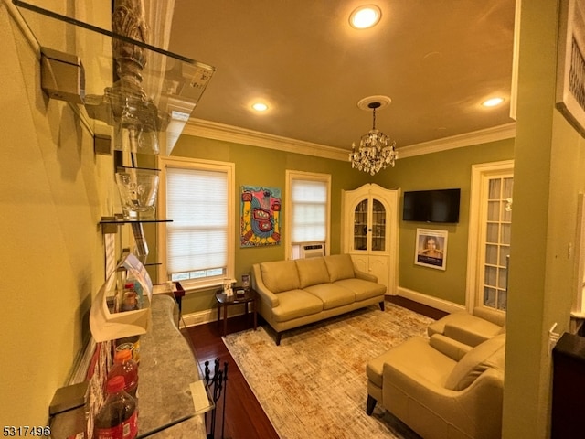 living room featuring ornamental molding, a chandelier, and wood-type flooring