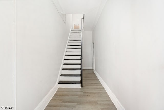 staircase featuring hardwood / wood-style flooring and ornamental molding