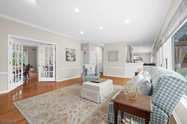 living room featuring baseboards, recessed lighting, light wood-style flooring, and crown molding