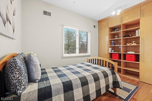 bedroom with wood finished floors and visible vents