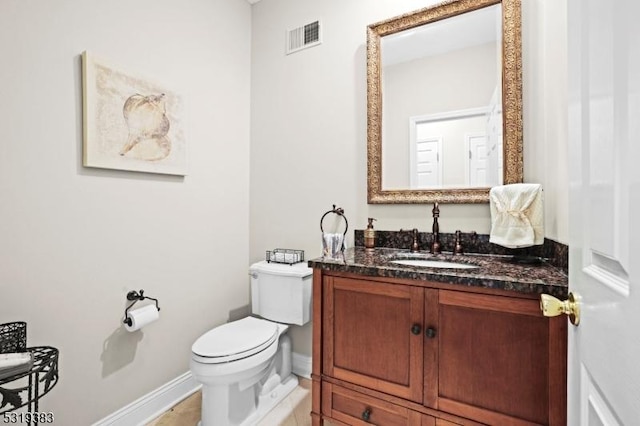 bathroom featuring toilet, baseboards, visible vents, and vanity