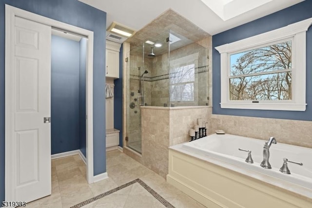 bathroom with tile patterned flooring, a garden tub, a shower stall, and baseboards