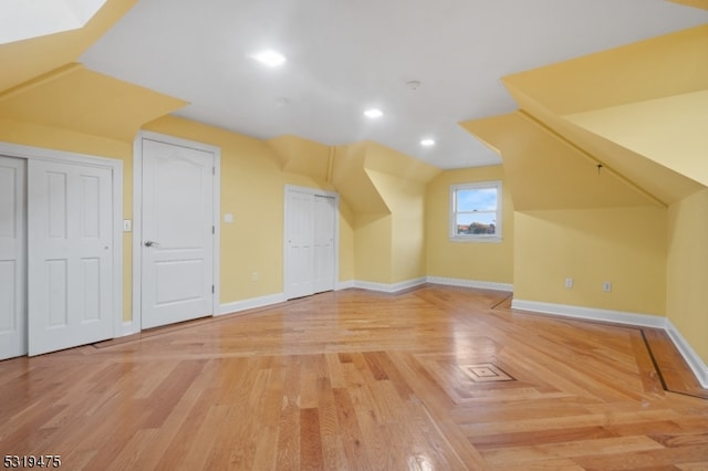 additional living space featuring wood-type flooring and lofted ceiling