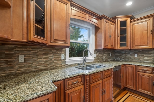 kitchen with dishwasher, light stone countertops, sink, and backsplash