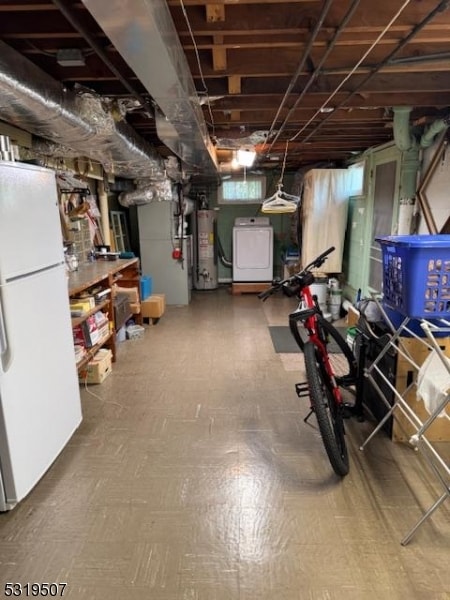 basement featuring white fridge, washer / dryer, and water heater