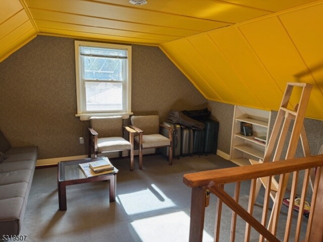 additional living space featuring lofted ceiling and built in shelves