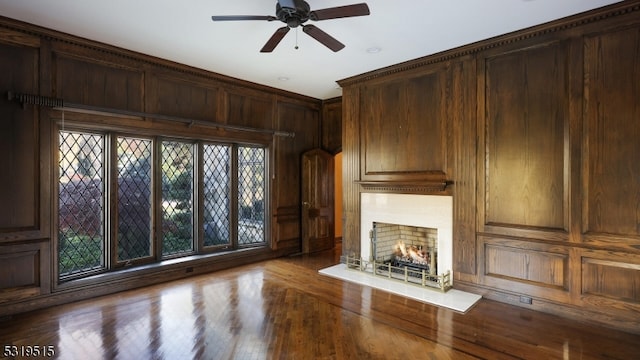 unfurnished living room featuring ceiling fan, wood walls, and hardwood / wood-style floors