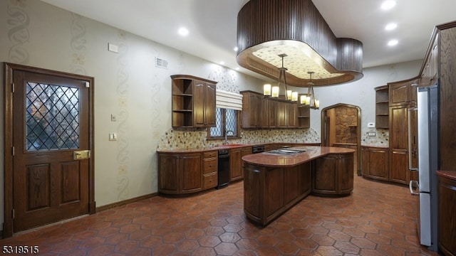 kitchen with appliances with stainless steel finishes, sink, a kitchen island, hanging light fixtures, and decorative backsplash