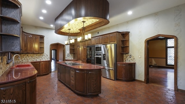 kitchen with hanging light fixtures, appliances with stainless steel finishes, a chandelier, sink, and a center island