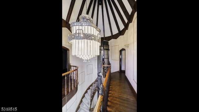 corridor featuring dark wood-type flooring and a chandelier